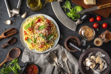 Seramik tabakta makarna ve siyah arka planda malzemelerle İtalyan yemeği. Düz görüş. Üst görünüm.