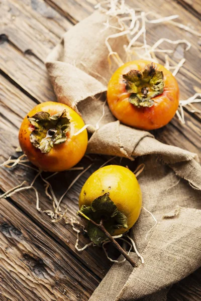 Ahşap masa, seçici odak üzerinde taze tatlı Trabzon hurması