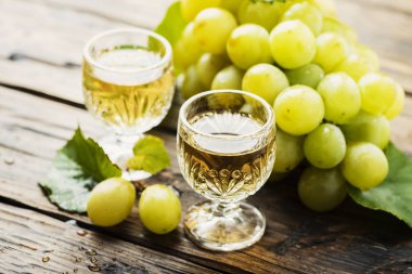 Tipik İtalyan altın grappa ahşap masa üzerinde sarı üzüm ile