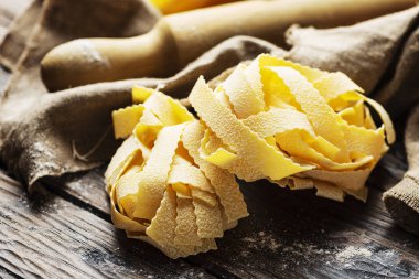 Koyu ahşap masa üzerinde ham İtalyan pappardelle