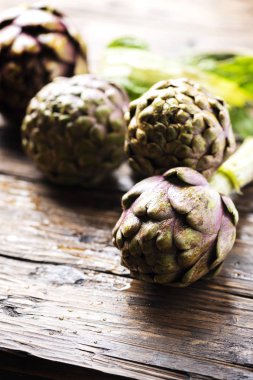 Ahşap masa, seçici odak resim üzerinde ham İtalyan enginar