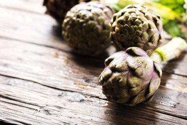 Ahşap masa, seçici odak resim üzerinde ham İtalyan enginar