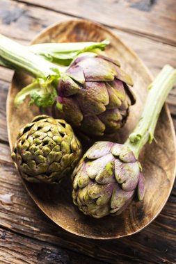 Ahşap masa, seçici odak resim üzerinde ham İtalyan enginar