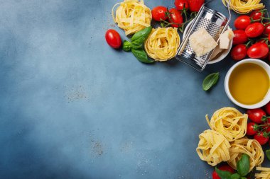 Çiğ tagliatelle, domates, fesleğen, zeytinyağı, tuz ve biberli İtalyan yemeği kavramı. Kopyalama alanı olan en üst görüntü