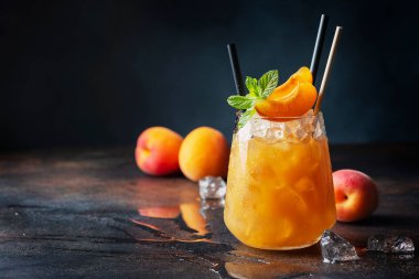Bar konsepti ve yaz içkileri konsepti. Kayısı, buz ve nane arkaplanda bir bardak yaz kokteyli. Seçici odak resmi.