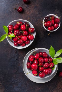Koyu arkaplandaki seramik kasede taze kirazın üst görüntüsü