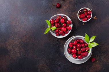 Koyu arkaplandaki seramik kasede taze kirazın üst görüntüsü