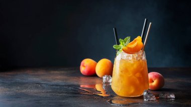 Bar konsepti ve yaz içkileri konsepti. Kayısı, buz ve nane arkaplanda bir bardak yaz kokteyli. Seçici odak resmi, kaydırma biçimi
