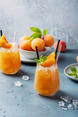 Mavi arka planda buzlu ve naneli taze kayısı kokteyli. Seçici odak resmi. Bar konsepti ve yaz içkileri
