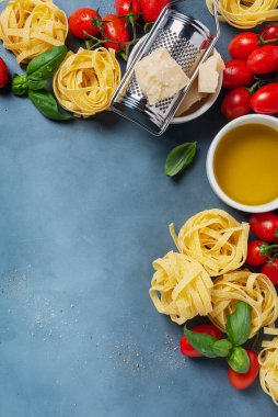 Çiğ tagliatelle, domates, fesleğen, zeytinyağı, tuz ve biberli İtalyan yemeği kavramı. Kopyalama alanı olan en üst görüntü