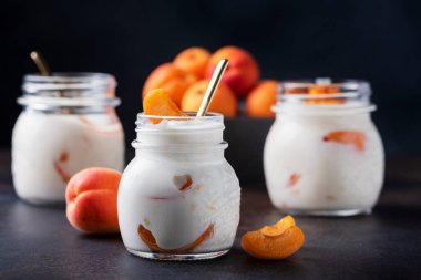 Koyu masada kayısısı olan sağlıklı bir yoğurt, seçici odak görüntüsü.
