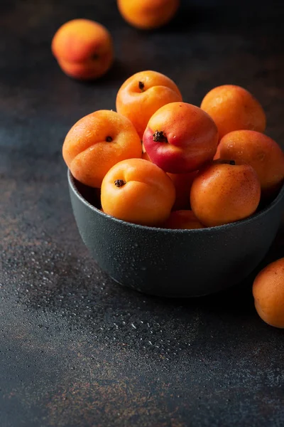 Concept of healthy vegan food with sweet apricots in a dark background, selective focus image