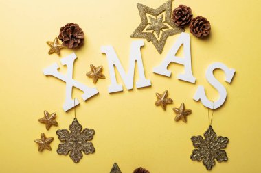 İçinde mektuplar ve sarı arka planda Noel süsleri olan bir Noel kartı. Noel konsepti, yukarıdan aşağı görünüm