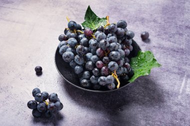 Karanlık masadaki tatlı siyah üzüm, seçici odak görüntüsü