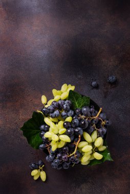 Koyu arkaplanda beyaz ve siyah üzüm karışımı, metin için kopya alanı ile üstten aşağı görünüm