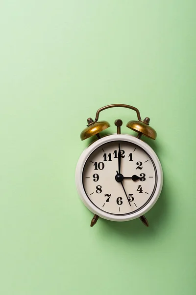 昼光時間の概念 緑の背景にレトロな時計 コピースペース付きのトップダウンビュー — ストック写真
