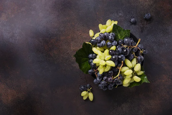 Koyu arkaplanda beyaz ve siyah üzüm karışımı, metin için kopya alanı ile üstten aşağı görünüm