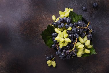 Koyu arkaplanda beyaz ve siyah üzüm karışımı, metin için kopya alanı ile üstten aşağı görünüm