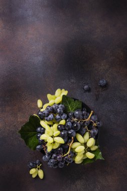 Koyu arkaplanda beyaz ve siyah üzüm karışımı, metin için kopya alanı ile üstten aşağı görünüm