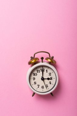 Gün ışığı kavramı zaman kazandırıyor. Pembe arka planda geriye dönük saat. Kopyalama alanı ile üstten aşağı görünüm
