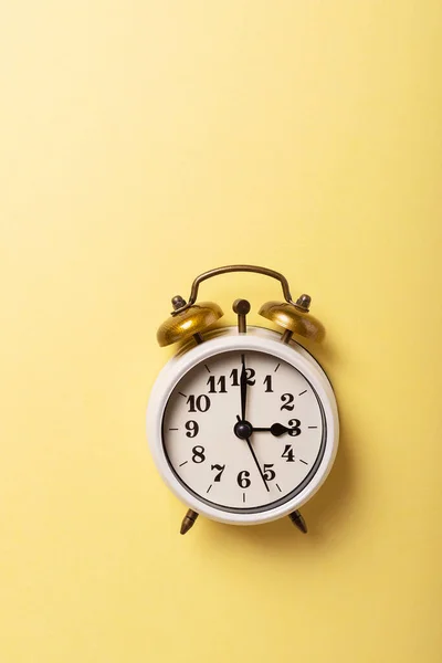 昼光時間の概念 黄色の背景にレトロな時計 コピースペース付きのトップダウンビュー — ストック写真