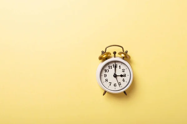 昼光時間の概念 黄色の背景にレトロな時計 コピースペース付きのトップダウンビュー — ストック写真