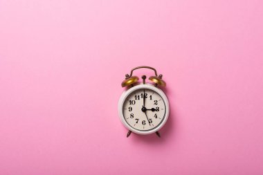 Gün ışığı kavramı zaman kazandırıyor. Pembe arka planda geriye dönük saat. Kopyalama alanı ile üstten aşağı görünüm