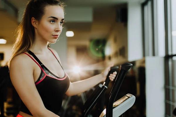 Young attractive woman doing cardio training in gym.
