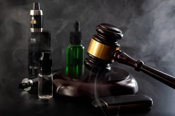 蒸気を制限する法律行為 電子タバコを吸うと黒の背景に隔離された裁判官のギャベル ベープ装置 ジュースと煙のボトルで禁止法の概念的なアイデア — ストック写真