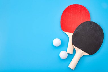 Pingpong dersi ve kırmızı ve siyah masa tenisi ya da mavi arka planda izole ping pong raketi ile yarışma konsepti kazanmak
