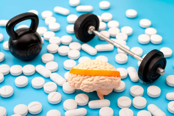 Zihinsel zindelik, akıl sağlığı ve nootropik uyuşturucu konsepti için insan beyninde saç bandı, halter, kettlebell ve nootropik ilaç takviyesi