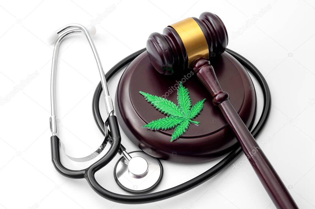 Legal medicinal marijuana, weed dispensary and therapeutic use of cannabis concept theme with a hemp leaf, medical stethoscope and a wood gavel isolated on white background