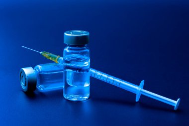 Aşılar, botulinyum toksini ve insülin ampülleri konsept temalı cam şişeler ve temiz sıvıyla siyah arka planda izole edilmiş şırınga ve şırınga.