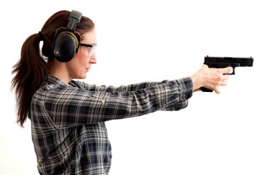 İkinci yasa değişikliği, nefsi müdafaa ve atış poligonu kavramında silah kullanımı silah doğrultulan ve beyaz üzerine izole edilmiş koruyucu giysi giyip ateş etmeye hazır olan bir kadınla.