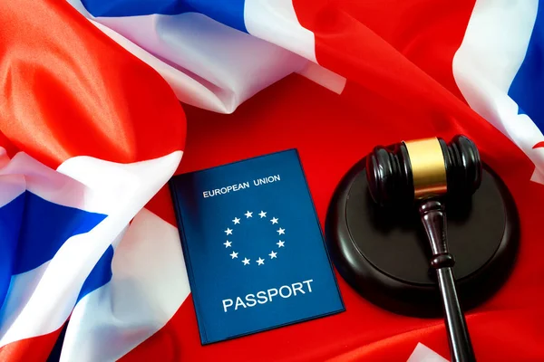 Einwanderungsrecht, Brexit und Bürgerrechte in Großbritannien Konzeptthema mit EU-Pass und einem hölzernen Hammer gegen die britische Flagge, auch Union Jack genannt — Stockbild Einwanderungsrecht Brexit Und Bürgerrechte Großbritannien Konzeptthema Mit Pass Und Einem — Stockfoto