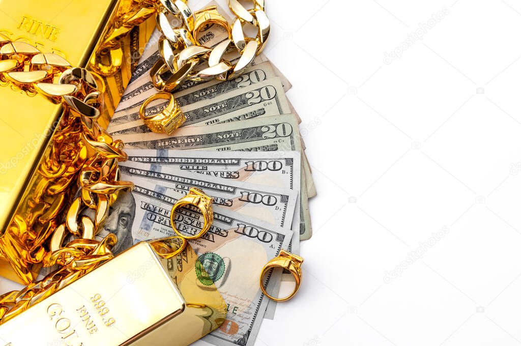 Jewelry buyer, pawn shop and buy and sell precious metals concept theme with a pile of cash in US dollars, golden rings, necklace bracelet and gold bullion isolated on white background with copy space