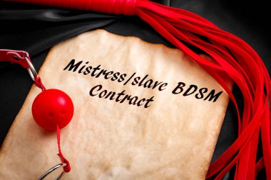 BDSM sözleşmesi veya seks oyuncakları ile köle sözleşmesi kavramı, top şakası ve eski bir kağıt parçasının etrafında siyah ipek üzerine metni olan bir kırbaç.