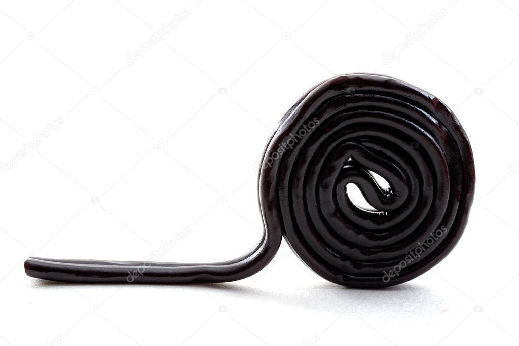 Sugar confectionery sweets and sweet candy concept with one black licorice or liquorice wheel or spiral isolated on white background