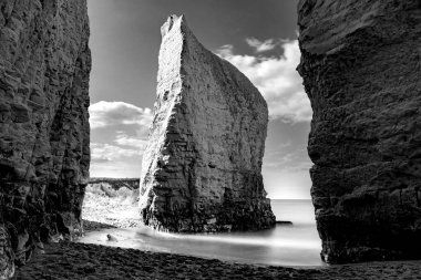 Atmosferik tebeşir ikonik dik uçurumun tek renkli fotoğrafı ve Botany Körfezi, Broadstairs, Kent, Birleşik Krallık 'ta ipeksi ince bir sis oluşturan dalga akışının uzun süre maruz kaldığı rüya gibi sükunet kavramı.