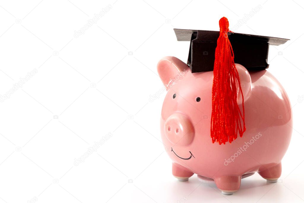College education costs, tuition financial aid, university graduate economic cost concept theme with close up on piggy bank wearing a graduation cap isolated on white background with copy space