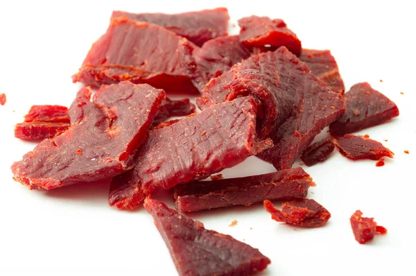 High protein diet and food that is high in sodium and salt concept theme with close up on beef jerky meat strips isolated on white background