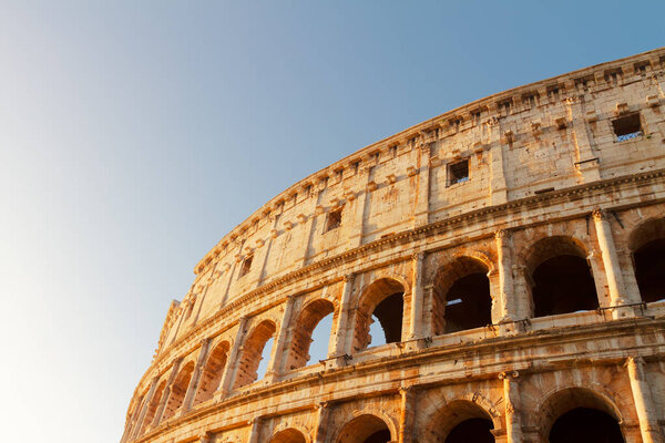 Ruins of Colosseum close up view at sunrise light in Rome, Italy