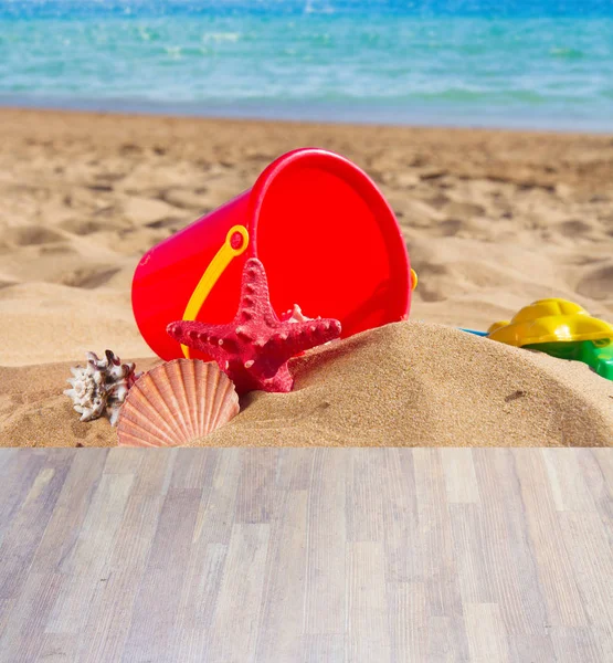 Bucket with seshells in sand on sea shore — Stock Photo, Image