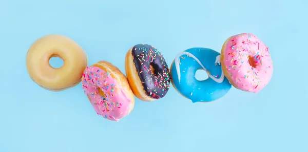 Fliegende Donuts auf blau — Stockfoto