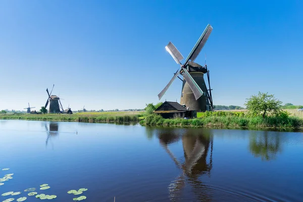 Dutch windmill over river waters — Stock Photo, Image
