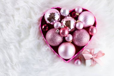 Beyaz kürk üzerinde pembe Noel süsleri