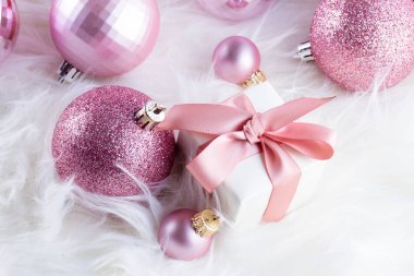Beyaz kürk üzerinde pembe Noel süsleri