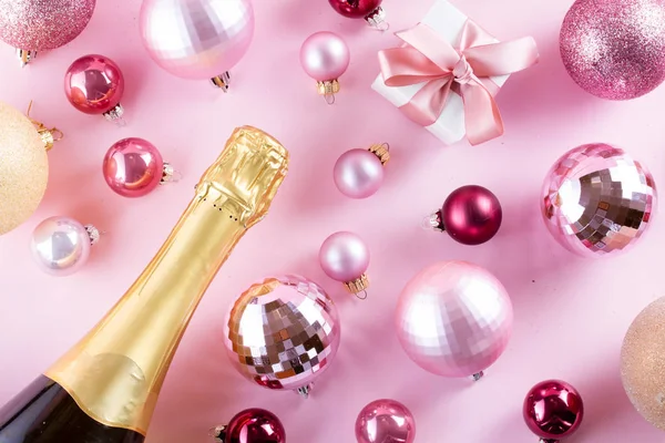 圣诞派对与香槟瓶和礼品盒在粉红色的背景 — 图库照片