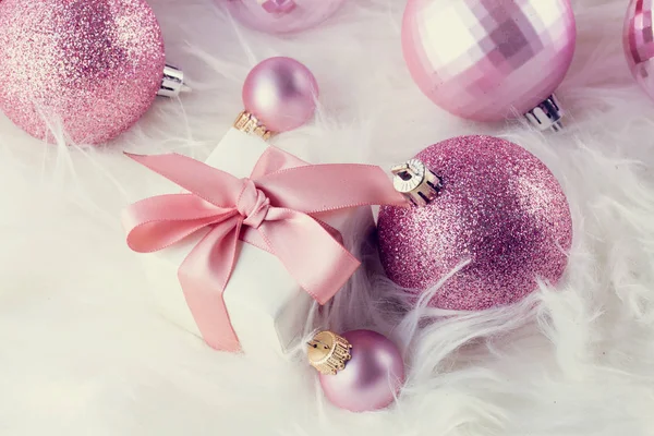 Rosafarbener Weihnachtsschmuck auf weißem Fell — Stockfoto