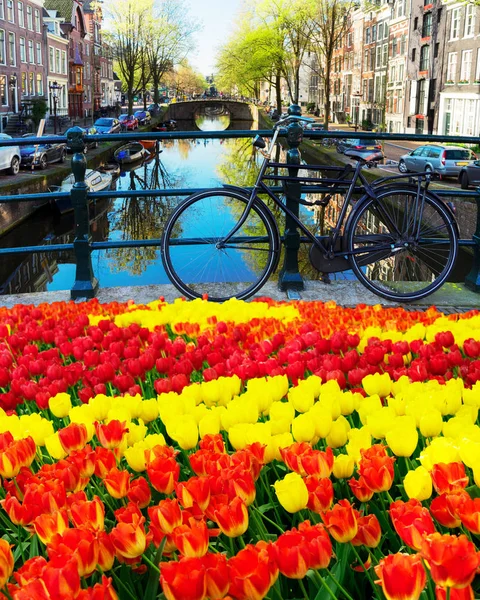 Oude fiets naast gracht van Amsterdam — Stockfoto